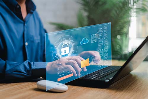 Man in a blue shirt working on laptop. Screen displays and image of Cybersecurity privacy data protection concept and document management concept,Businessman use laptop secure encryption to access data and documents Safe storage of confidential data of company system